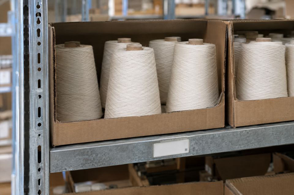 Shelf with stored yarn cones in cartons